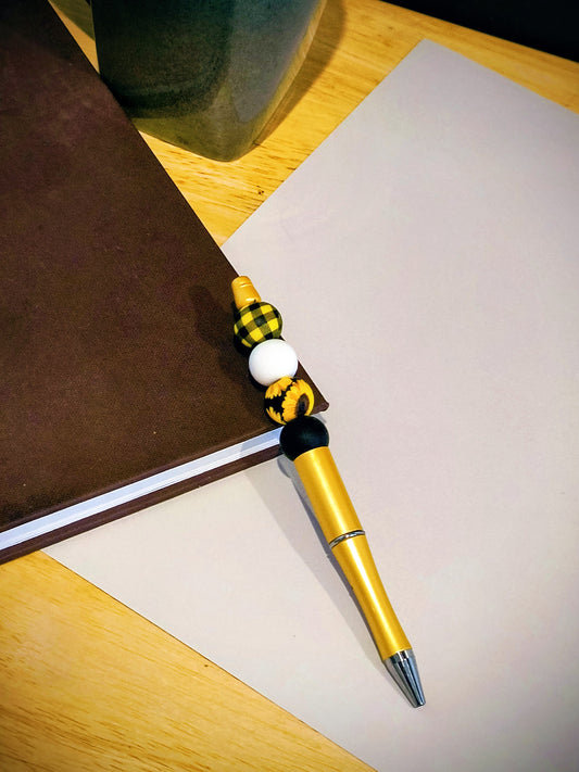 Be the talk of the office with these wonderful colorful fun pens. Each pen comes with an extra ink cartridge. This is Black and Yellow Checkered Decorative Sunflower decor on a Gold Glitter Pen. 
Dimensions 5.75" x .5" x .5". Weight .50 Oz.