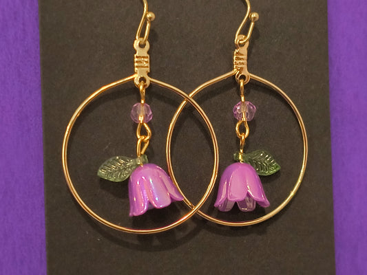 Purple Dangling Earrings With Lily Flowers In A Gold Circle
Dimensions H 1.75" x L 1.25" x W 0.375". Weight 0.10 Oz.