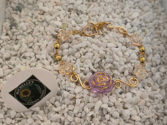 Spiral Wire Rose Bracelet With Gold Heart Clasp
This Handmade Bracelet has Gold Spiral Wire Between White and Light Purple Flowers. Gold Beads and a Cute Gold Heart Shaped Clasp.
Dimensions H 7" x L 1" x W 0.375". Weight 0.24 Oz.