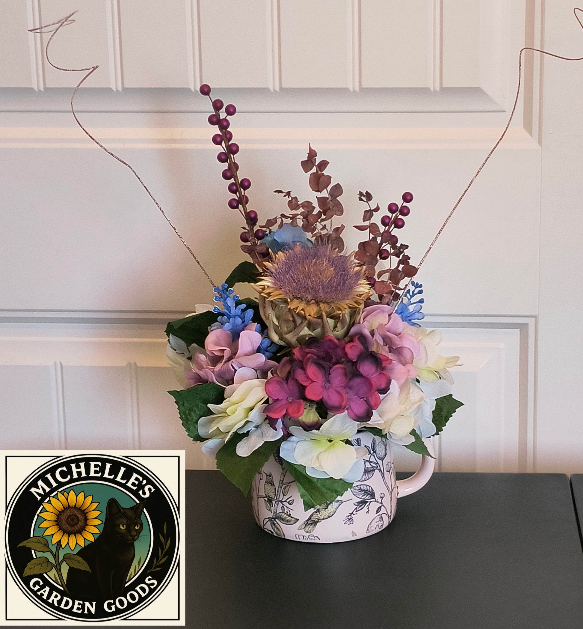 Hydrangea And Dried Artichoke Floral Arrangement In A Ceramic Teapot With A Bird Design