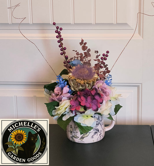 Hydrangea And Dried Artichoke Floral Arrangement In A Ceramic Teapot With A Bird Design