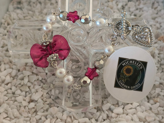 Coquette Beaded Bowtie Pearl Bracelet With Rhinestone Heart Clasp in Silver 
Dimensions H 7" x L 1.125" x W 0.375". Weight 0.40 Oz.