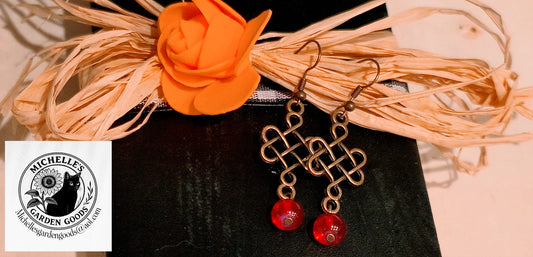 Trinity Knot Cross Design Earrings With Red Glass Beads 
Hypoallergenic material: Alloy, Brass, Iron, Glass, cadmium Free & Nickel Free  & Lead Free.
Dimensions H 2" x L 0.75" x W 0.375". Weight 0.18 Oz.