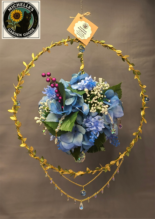 Floral Ball Suncatcher with Crystal Beads 
This Beautiful Piece Has Blue Butterfly Hydrangea Floral Arrangement floating in the Gold Leaf Suncatcher Circle Form. Many Crystal Beads Attached on the Ball of Blue Butterfly Hydrangea Flowers and Below the Circle. This Gorgeous Piece Would Be Beautiful for Home or Office Decor.
Dimensions 15" x 18" x 4". Weight 9.34 Oz.
