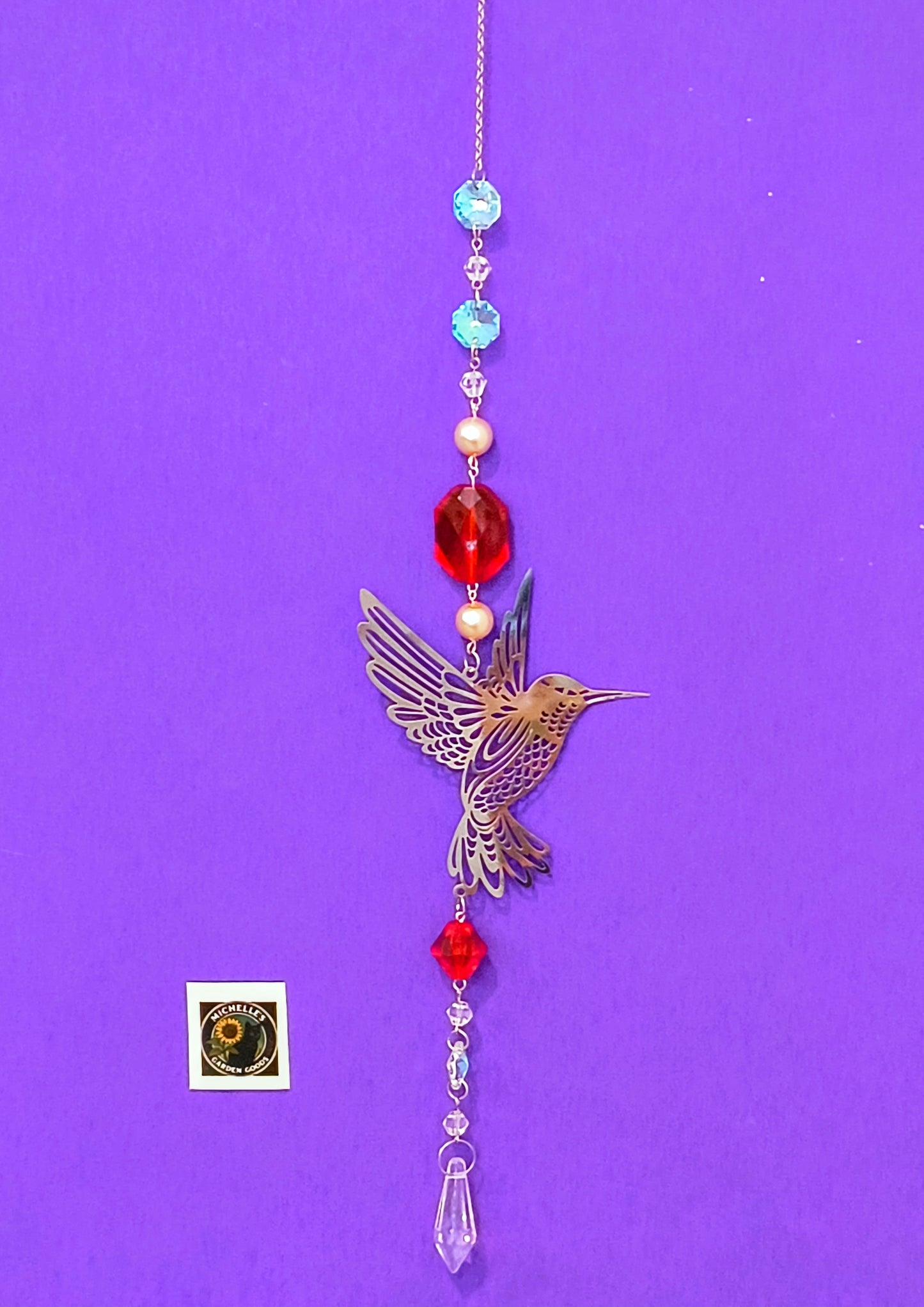 Single Strand Suncatcher With a Hummingbird in Red and Crystal Beads. This is a Sparkling Piece to Hang in the Garden or Home for Decor.
Dimensions 13" x 4" x 1 mm. Weight .95 Oz. 