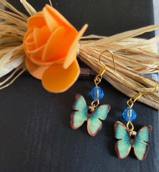 Blue Wooden Butterfly Earrings With Blue Glass Beads In A Gold Color
Dimensions H 1.75" x L 0.75" x W 0.25". Weight 0.04 Oz.