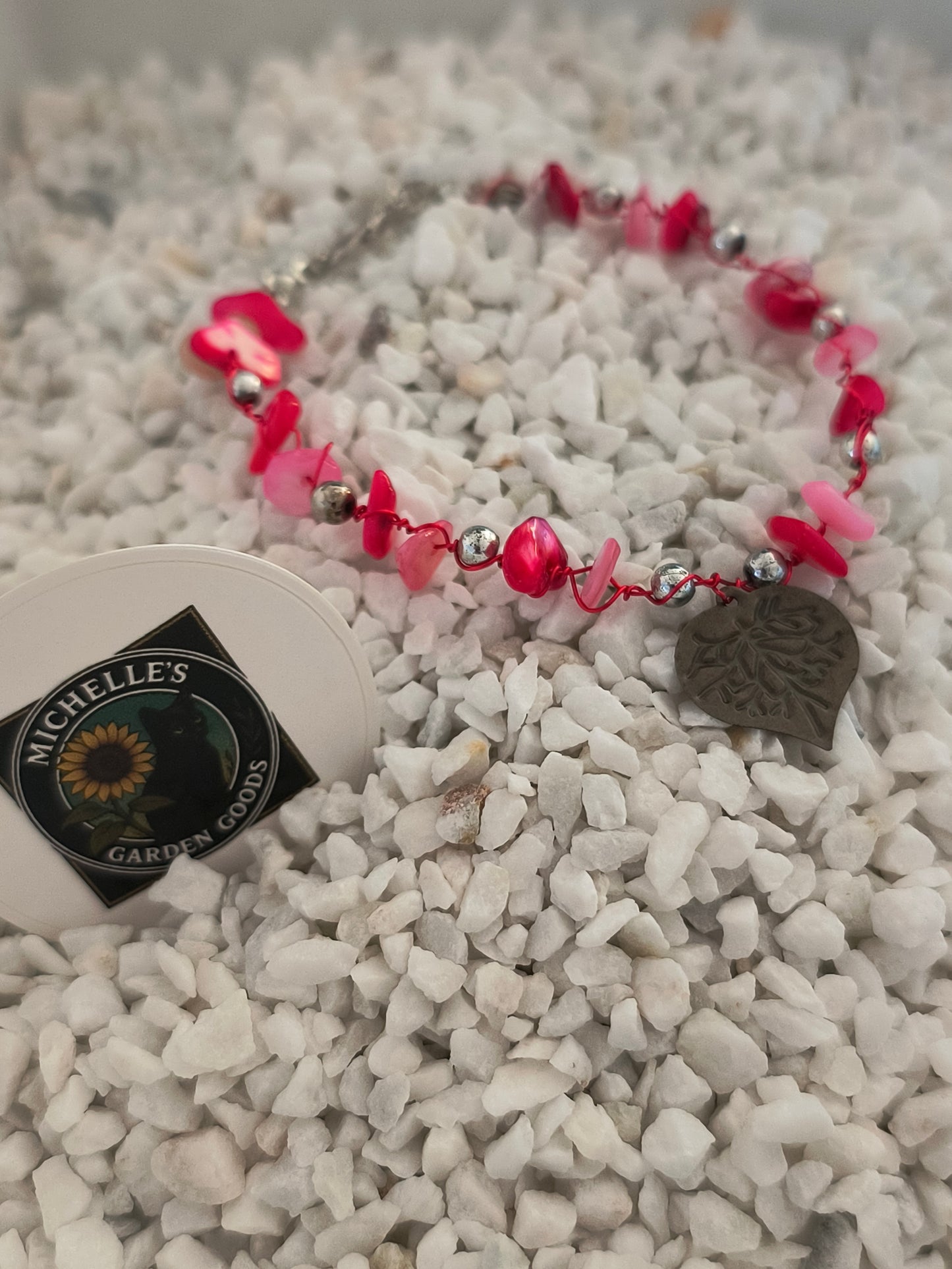 This Handmade Pink Coral Gemstone Bracelet With Tin Heart Wrapped around Silver Beads. 
Dimensions H 6.75" x L 0.875" x W 0.875". Weight 0.20 Oz.