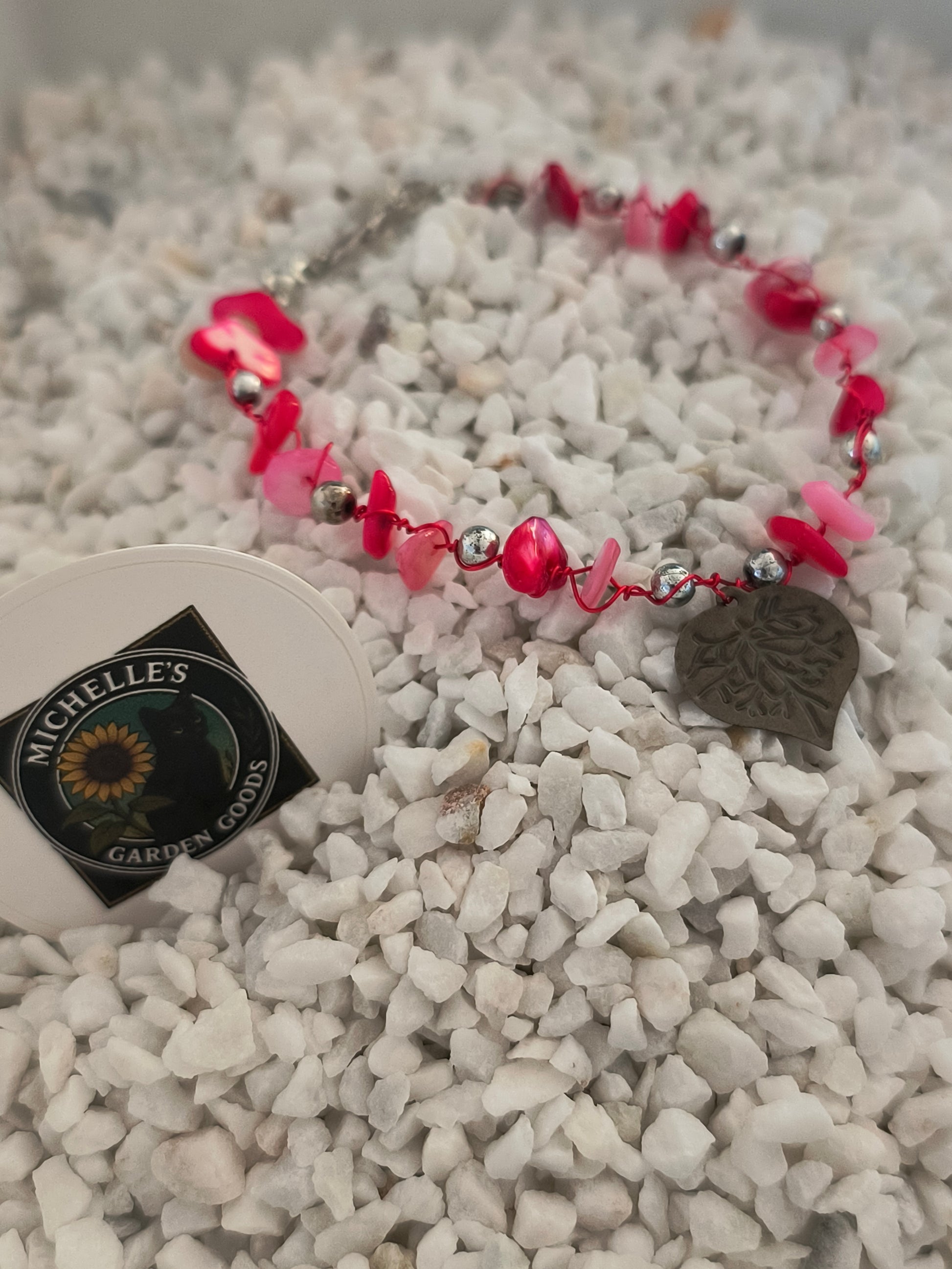 This Handmade Pink Coral Gemstone Bracelet With Tin Heart Wrapped around Silver Beads. 
Dimensions H 6.75" x L 0.875" x W 0.875". Weight 0.20 Oz.