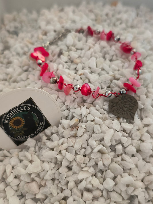 This Handmade Pink Coral Gemstone Bracelet With Tin Heart Wrapped around Silver Beads. 
Dimensions H 6.75" x L 0.875" x W 0.875". Weight 0.20 Oz.